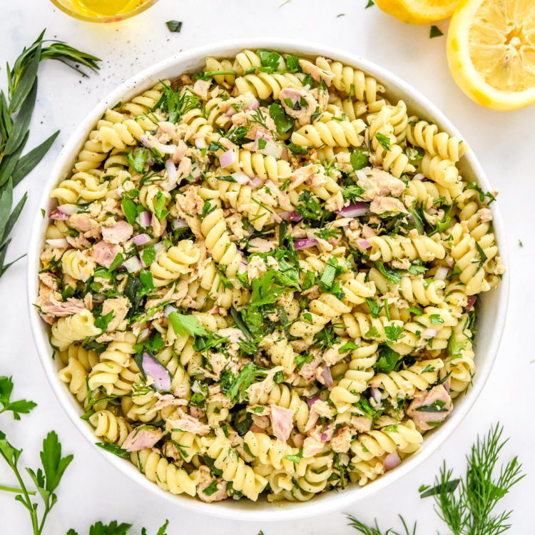 lemon vinaigrette tuna pasta salad with fresh herbs in a serving bowl.