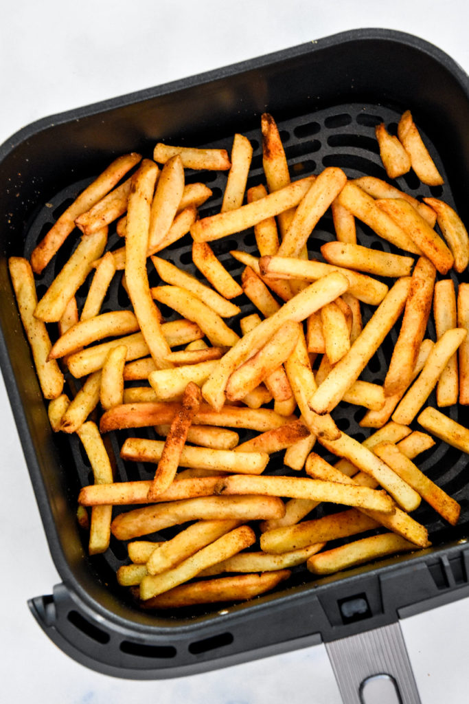 french fries in an air fryer basket.