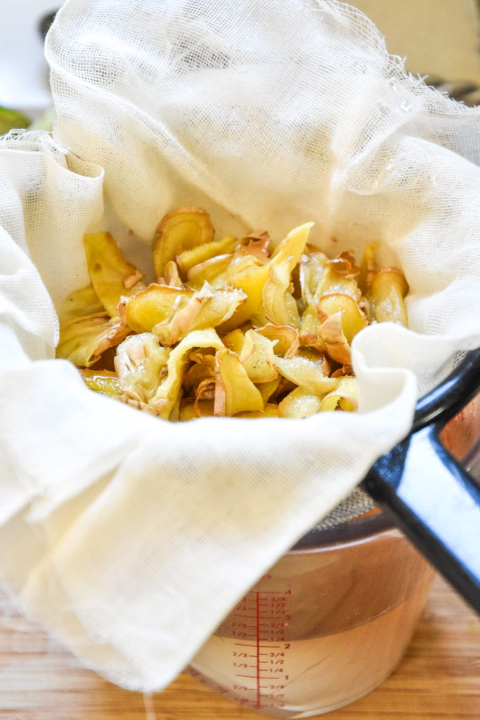 straining ginger from a homemade simple syrup.