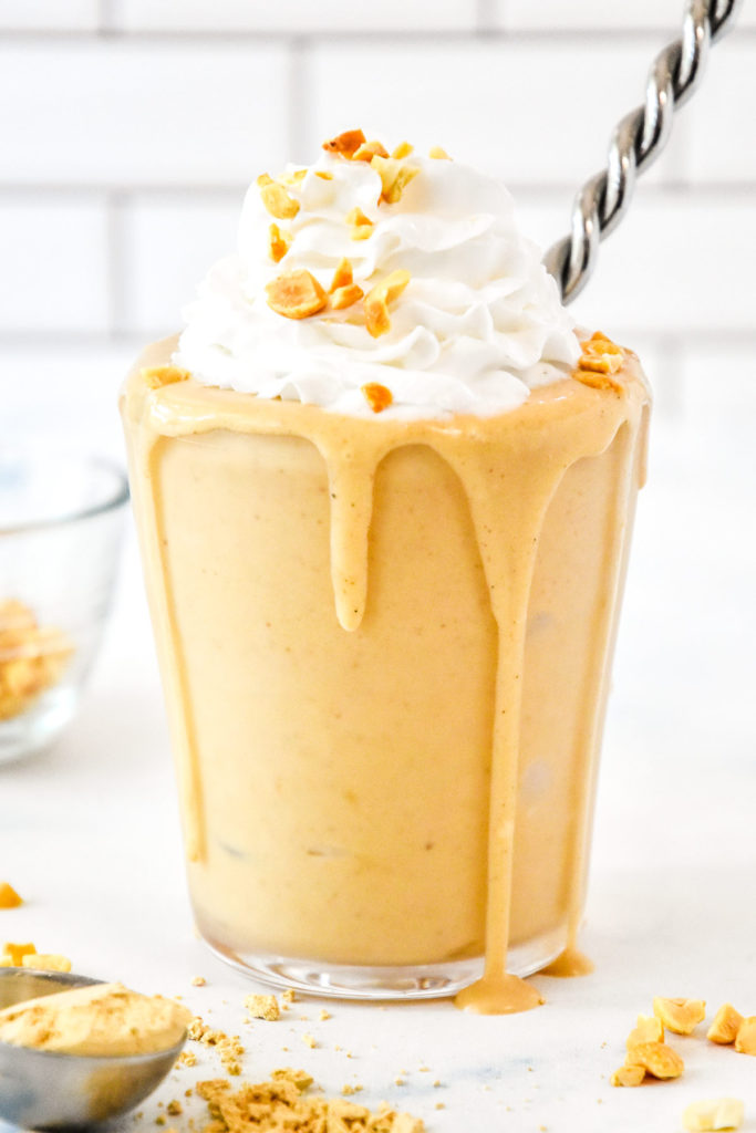 a peanut butter powder milkshake with whipped cream on top.