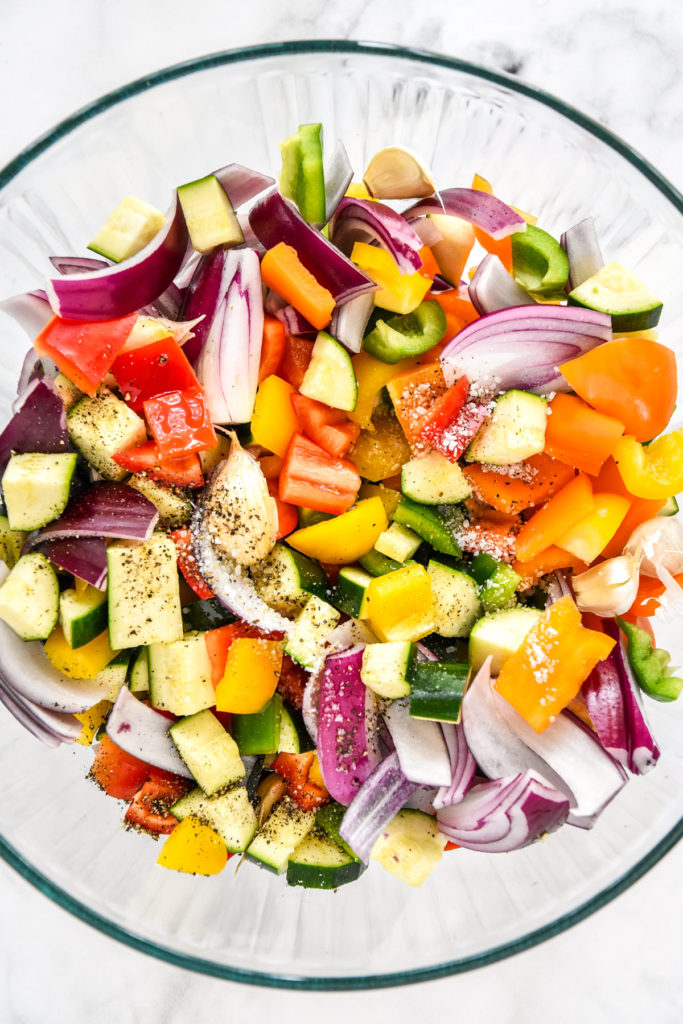 glass bowl of cut and seasoned colorful vegetables.