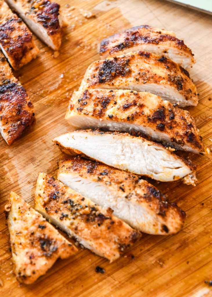 sliced cooked chicken breast on a cutting board.