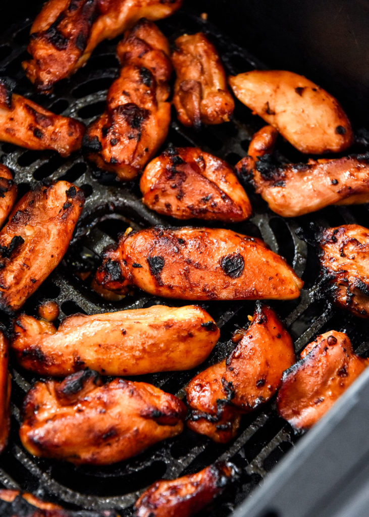 air fryer honey sriracha chicken in the air fryer basket.