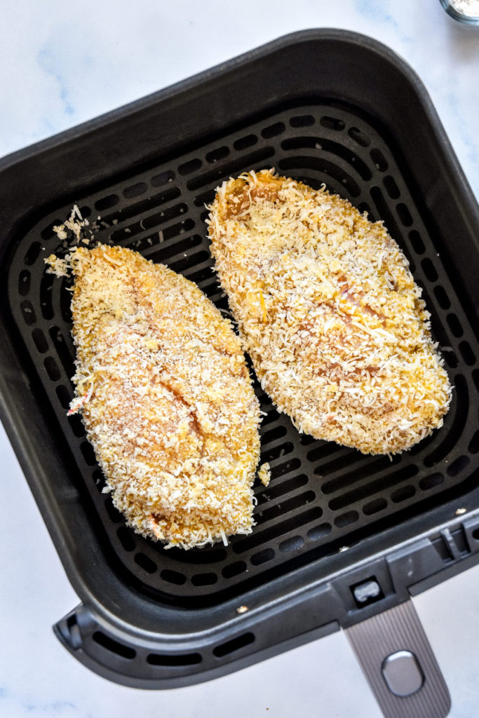 raw air fryer stuffed chicken parm in the air fryer basket before cooking.