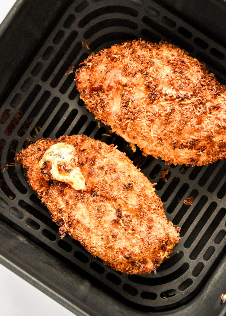 cooked air fryer stuffed chicken parm sitting in the air fryer basket.