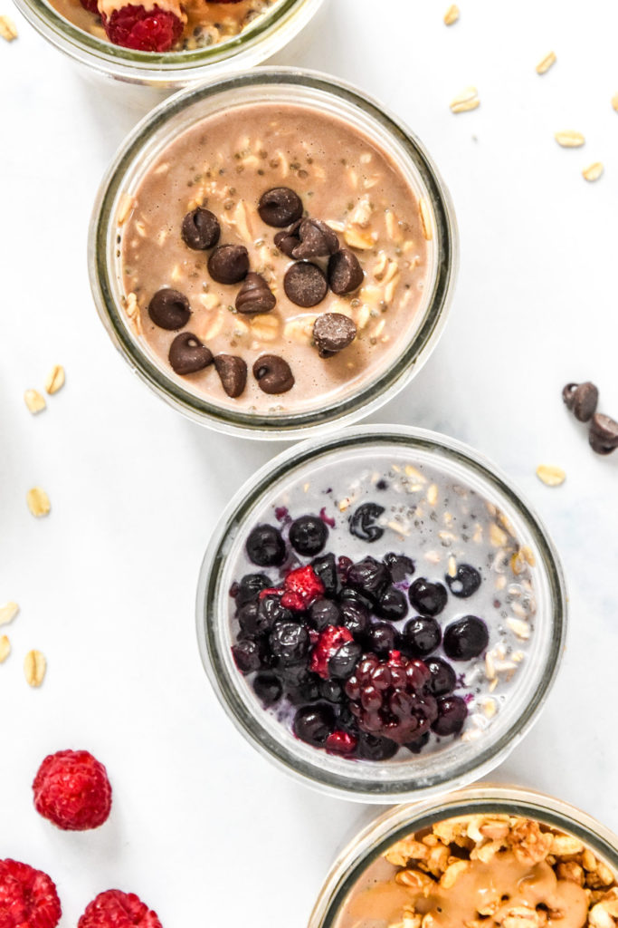 protein overnight oats base recipe chocolate and mixed berries in glass mason jars.