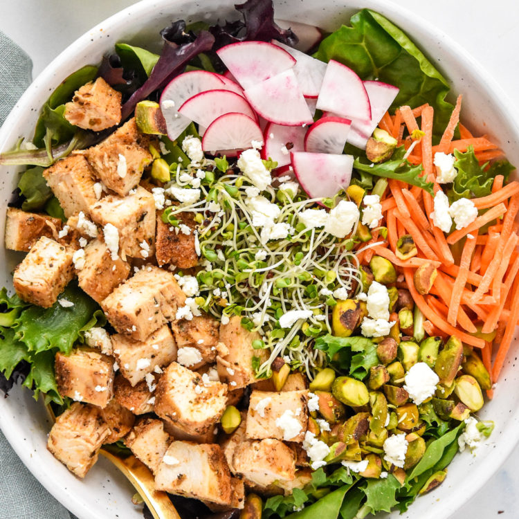 simple spring mix lunch salad with radish, microgreens, carrots, and diced chicken.