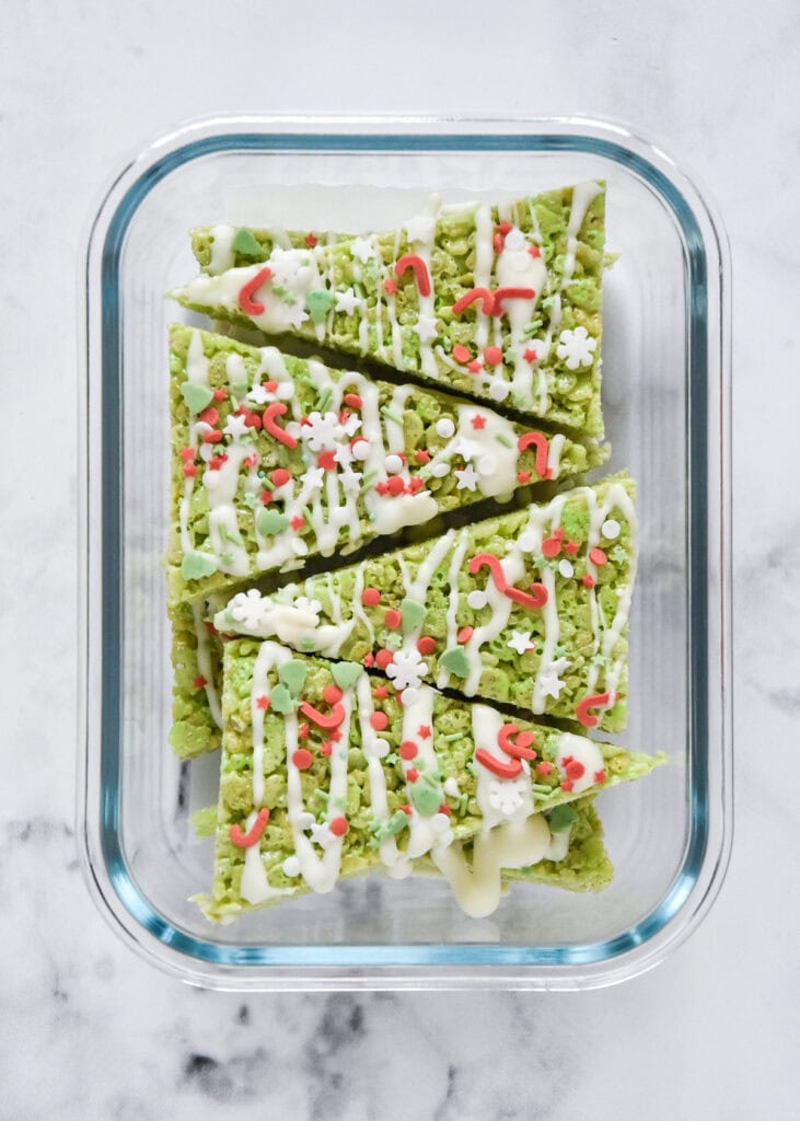 easy christmas tree rice krispies treats in a glass meal prep container.