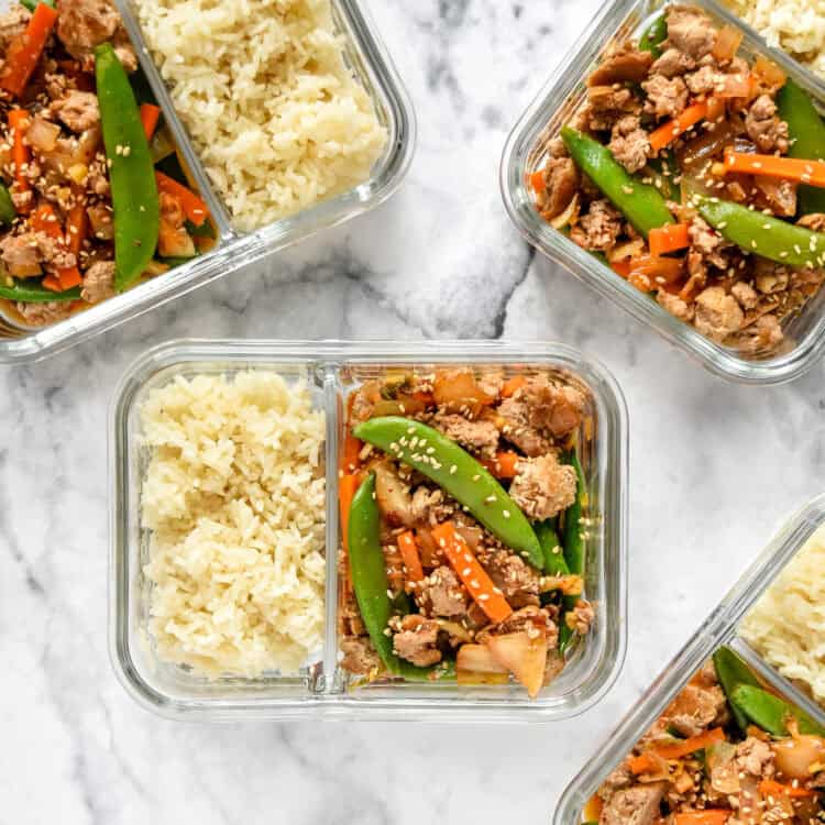 meal prep ground turkey stir fry bowls in glass meal prep containers with rice.