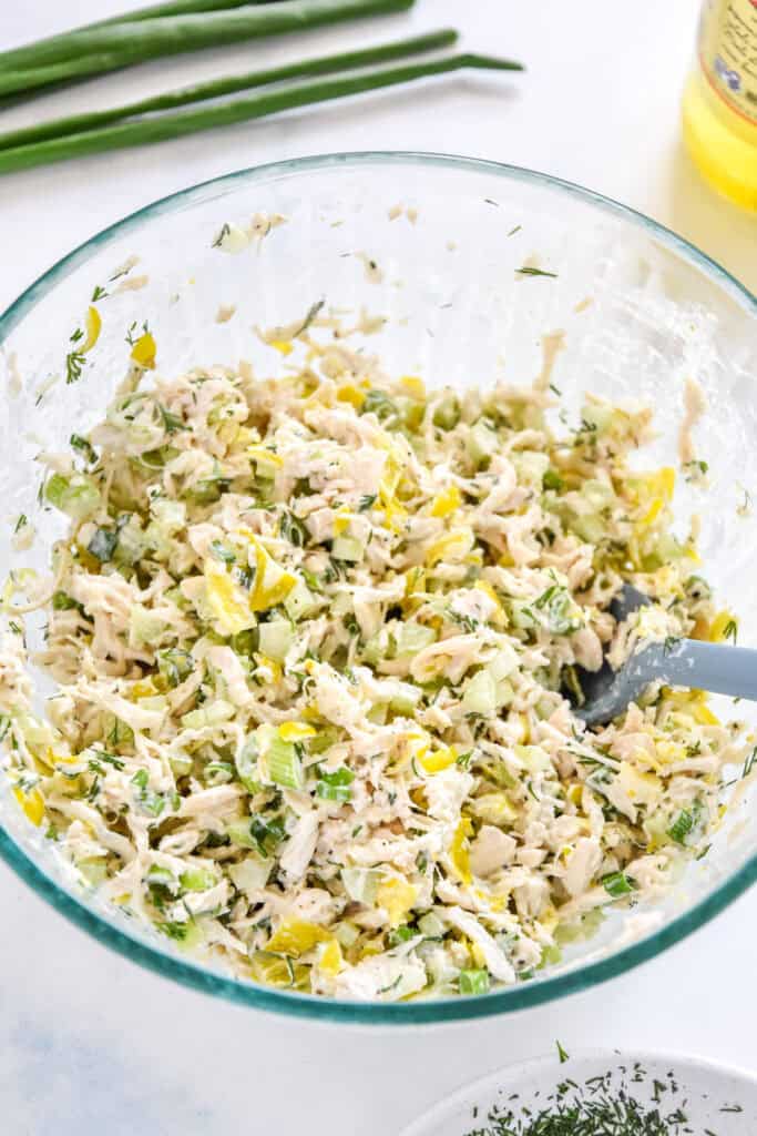 zesty pepperoncini chicken salad mixed together in a glass bowl.