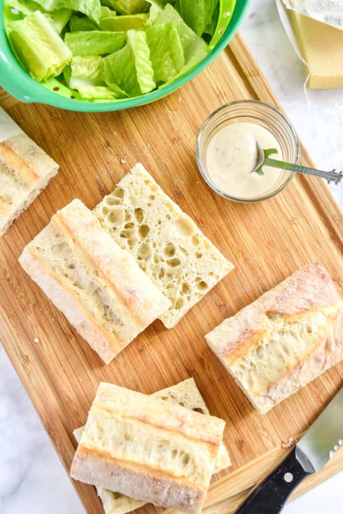 sliced ciabatta bread pieces on a cutting board.