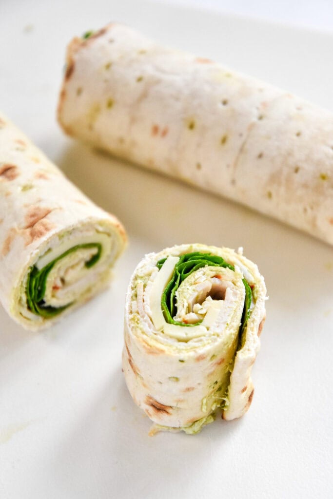 a slice of turkey pesto pinwheel with the inside showing.