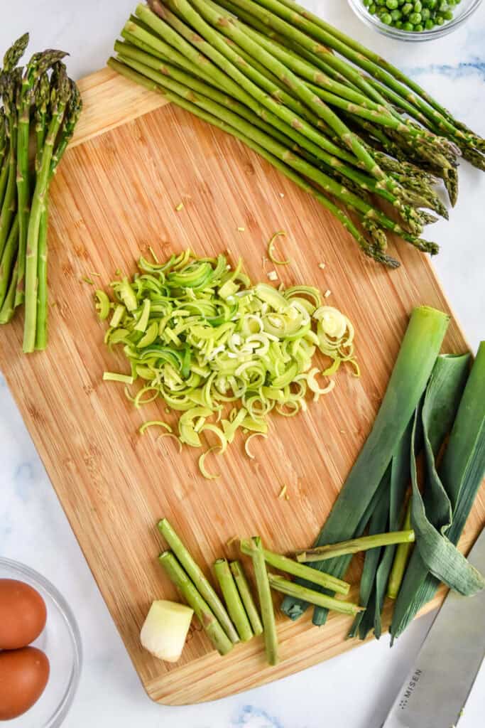 sliced leek on a bambook cutting board.
