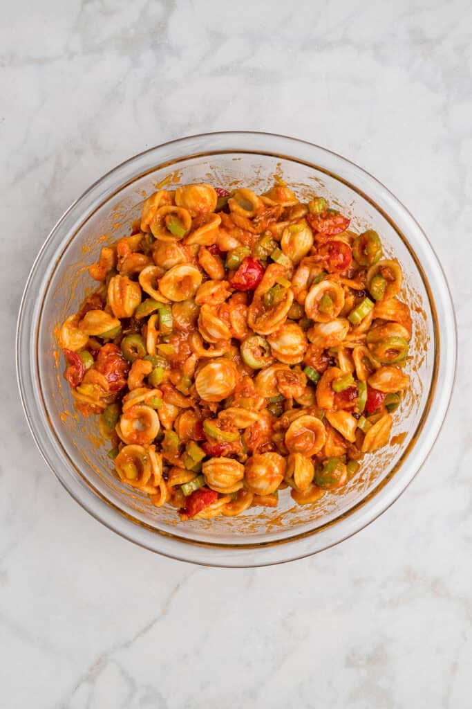 loaded bloody mary vinaigrette pasta salad in a large glass bowl.