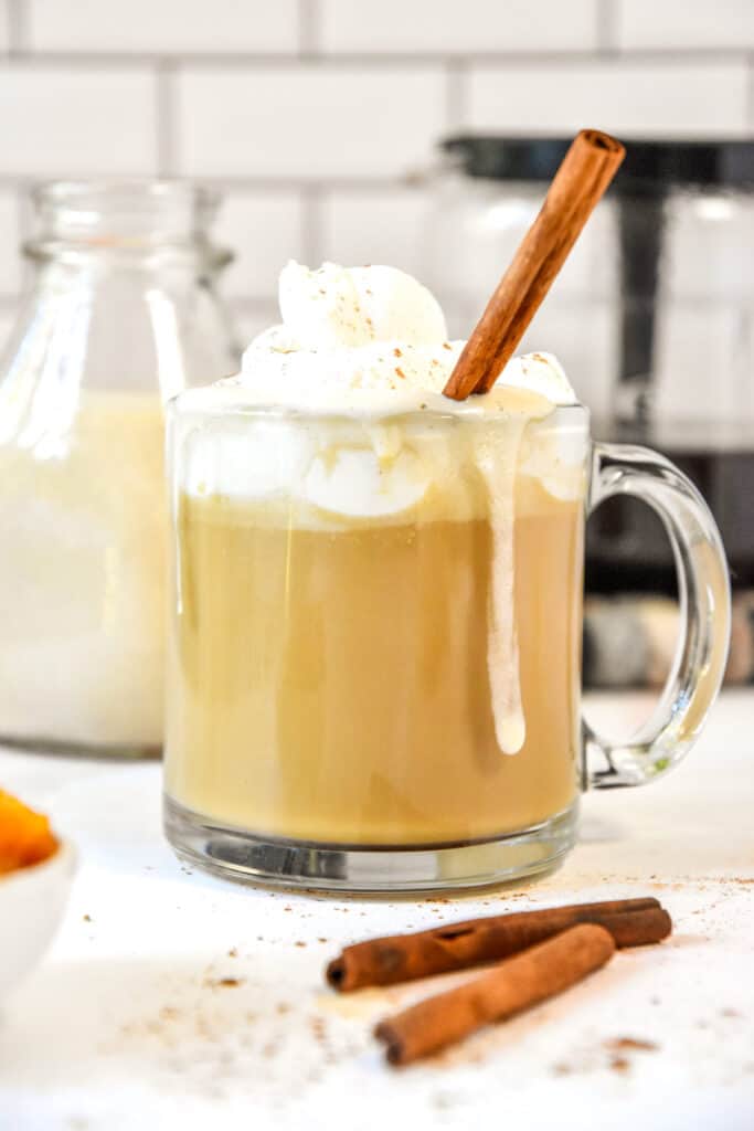 homemade pumpkin spice coffee creamer in a cup of coffee with whipped cream on top.