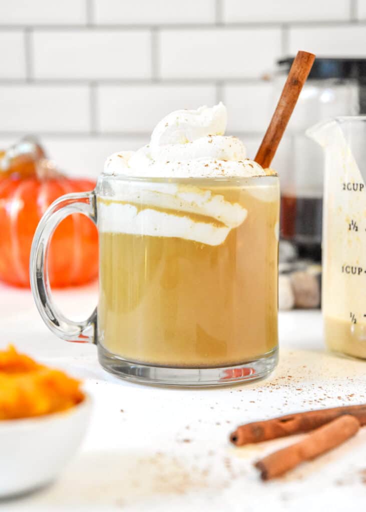 homemade pumpkin spice coffee creamer in a cup of coffee with whipped cream on top.