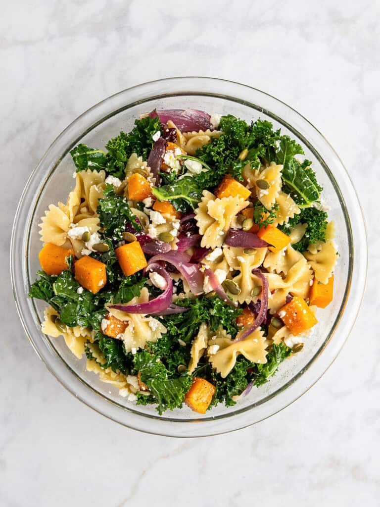 fall pasta salad with maple vinaigrette dressing after mixing everything together.